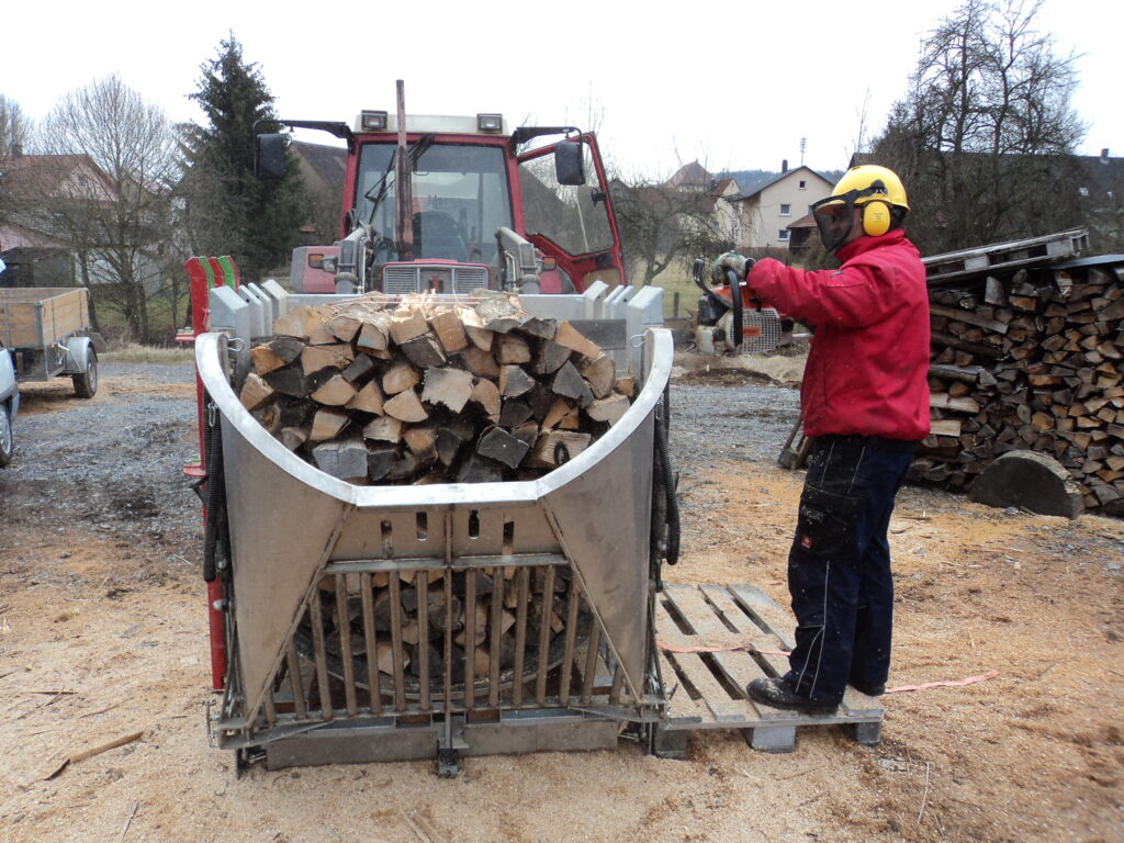 Brennholz wird am Holzspalter auf Scheitlänge gespalten